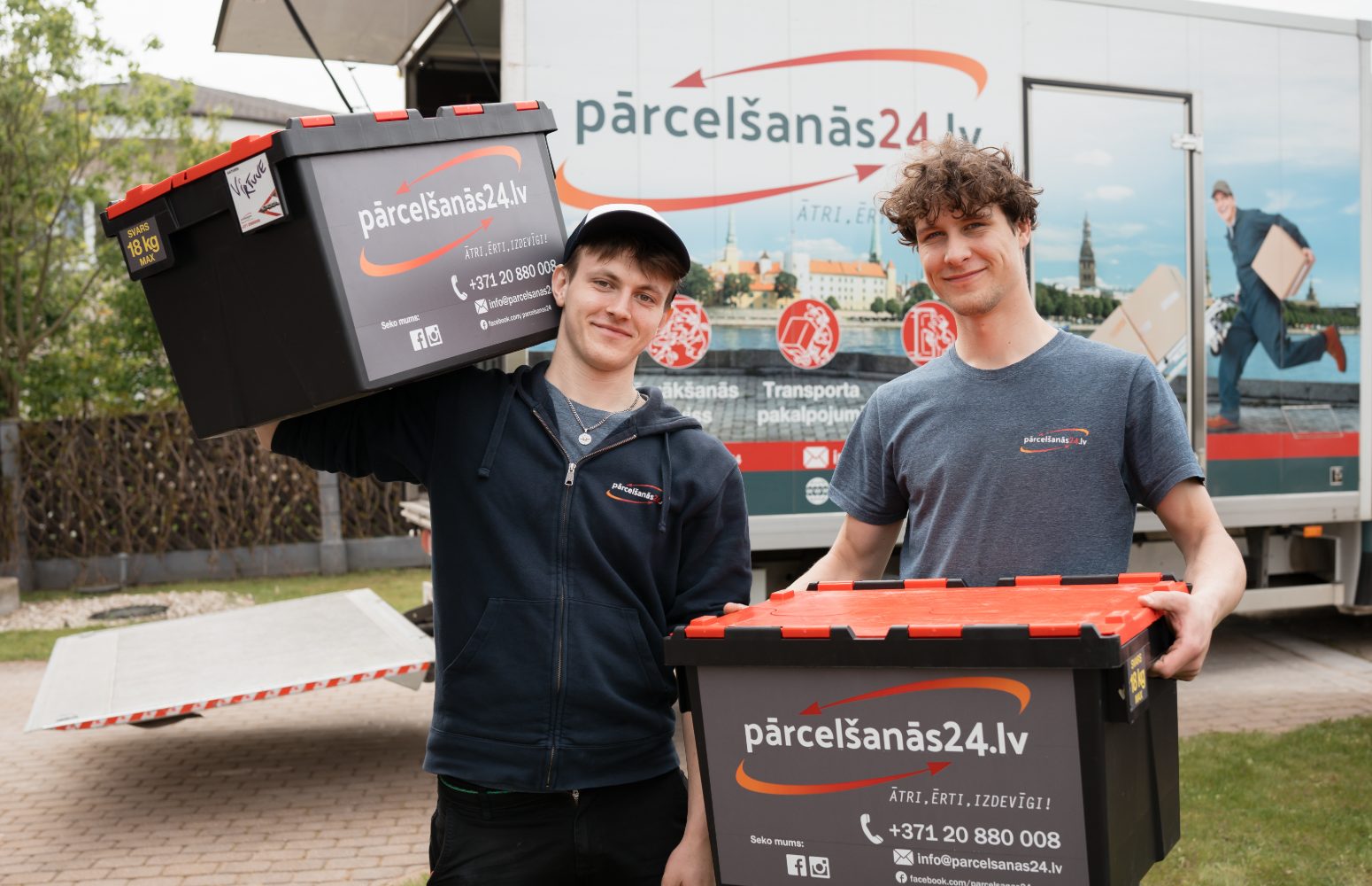 Pārcelšanās24 darbinieki ar kastēm pie firmas kravas auto